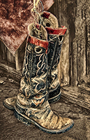 Cowboy boots hanging in barn.